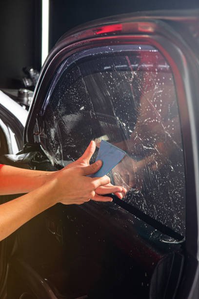 Car tinted detailing film installing on the windows glass