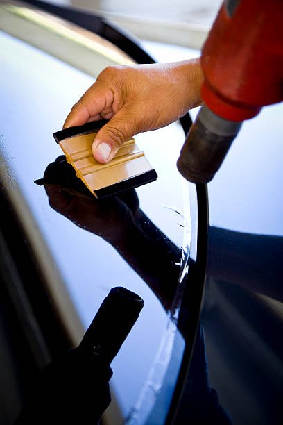 Man installing window tinting on car
